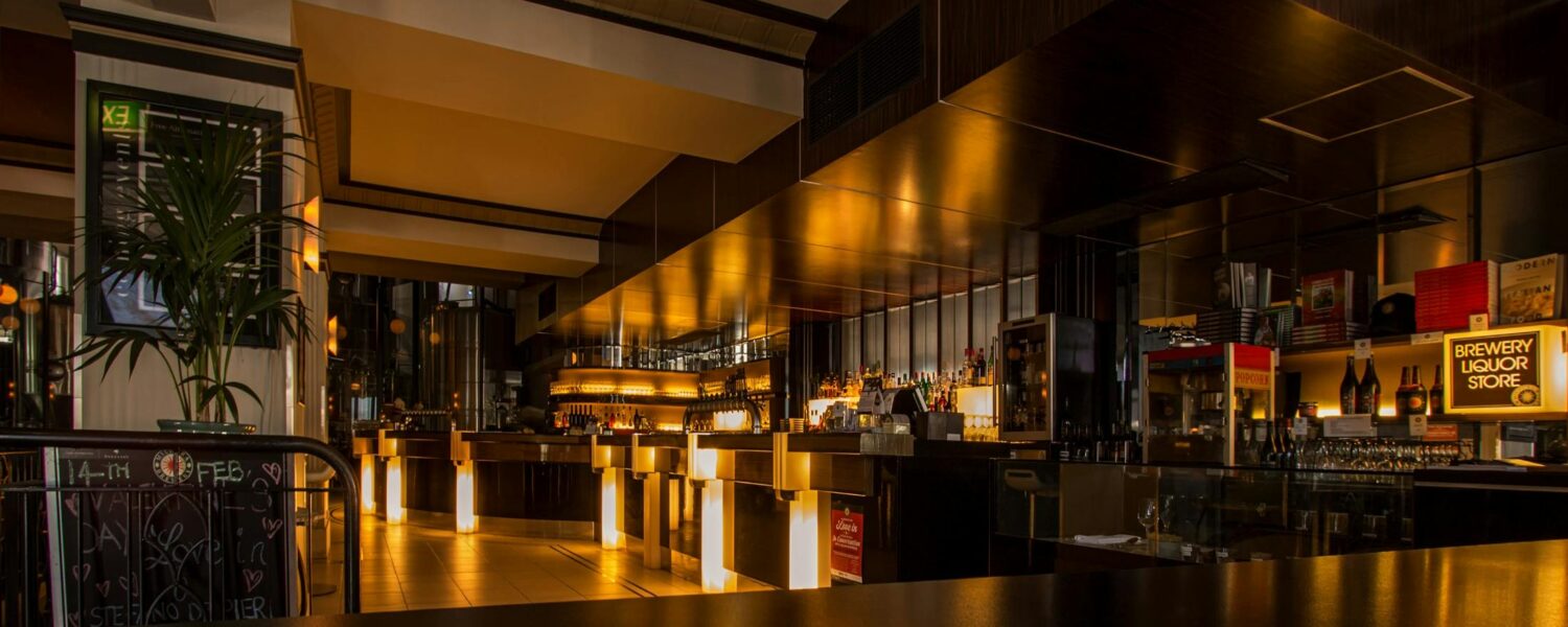 Stylish modern restaurant interior with warm lighting, elegant design, and luxurious ambiance at night.